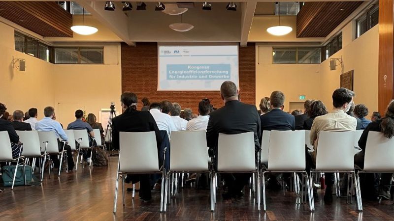 Kongressteilnehmer sitzen in einem Veranstaltungsraum beim Kongress Energieeffizienzforschung für Industrie und Gewerbe.