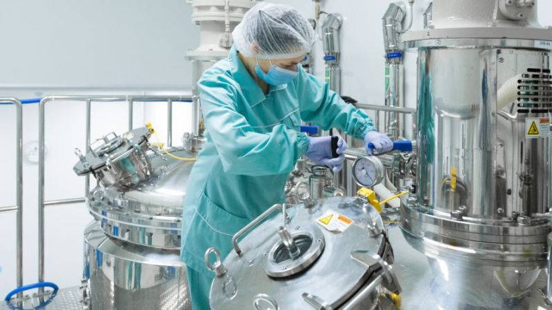 Symbolbild: Labor in der chemischen Industrie, Labormitarbeiterin arbeitet an verschiedenen Gefäßen und Anlagen