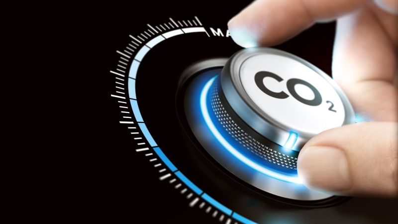 Eine Hand dreht an einem Rad mit der Aufschrift CO2