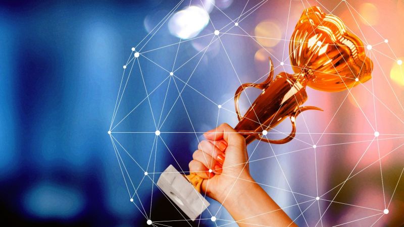 Nahaufnahme einer Hand, die einen Pokal hochrecht