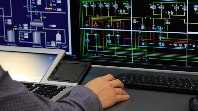 Nahaufnahme einer Hand auf einer Maus vor einem Computer-Bildschirm