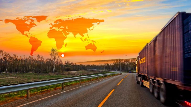 Lkw fährt auf einer Straße in Nordafrika während die Sonne untergeht