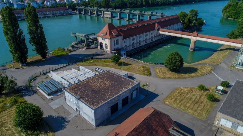 Luftaufnahme des Projektstandorts mit Wasserkraftwerk und Power-to-Hydrogen-Anlage am Wasser