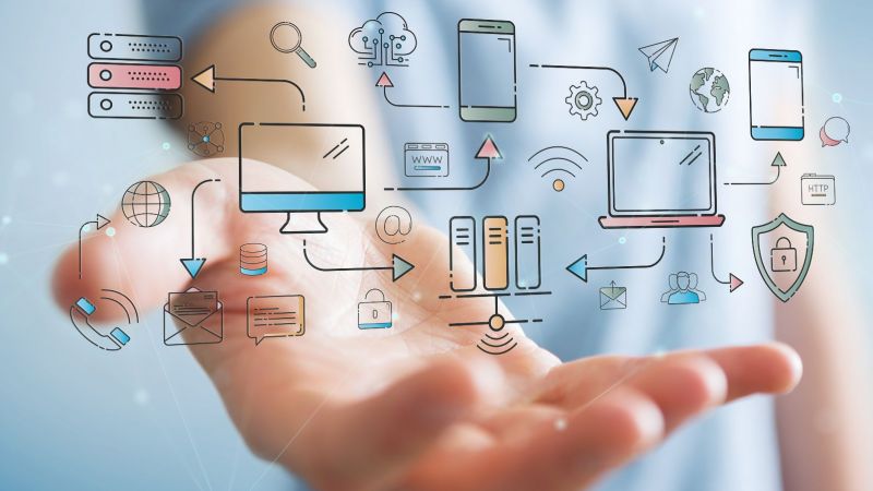 Nahaufnahme einer Hand, die in ihrer Handfläche vernetzte Symbole für Digitalisierung, Computer und IT-Technik hält