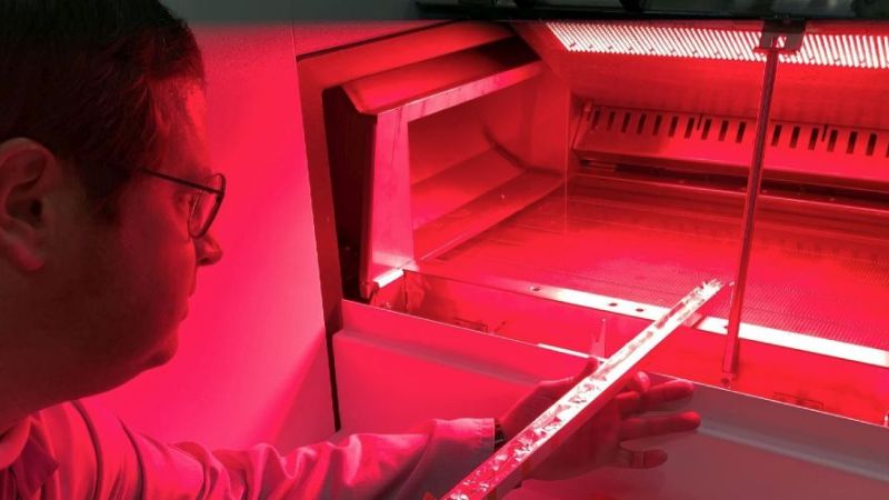 Using a measuring cell specially built for the project inside an aluminium rod, Dr Thomas Pernau measures the brightness of the regeneration furnace, which is closed for this purpose.