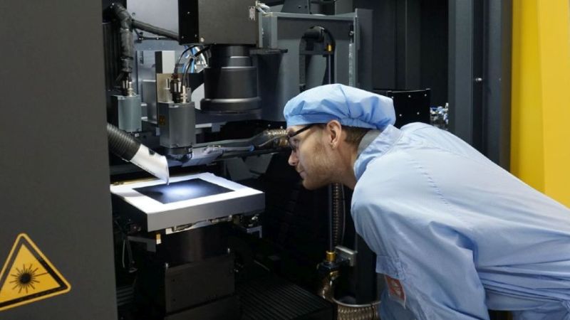 Das Bild zeigt einen Wissenschaftler des Fraunhofer ISE bei der Arbeit an einer Laser-Transfer und Feuer-Anlage.