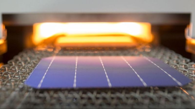 Das Bild zeigt den Eingang eines sogenannten Feuerofens, in den ein industrieller Solarwafer einfährt.