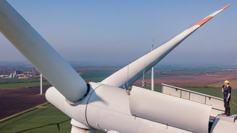 Nacelle of a wind turbine with worker on the turbine.