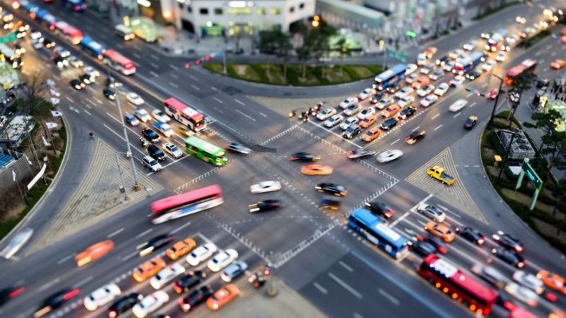 Das Foto zeigt eine belebte Verkehrskreuzung in einer Stadt.