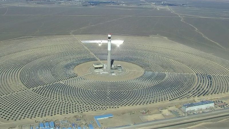 Ein Solarturmkraftwerk, zahlreiche Heliostaten sind um einen Solarturm gruppiert.