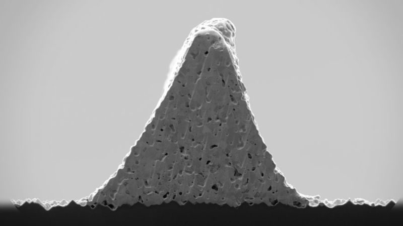 Scanning electron microscope image of a solar cell front contact with a triangular cross-sectional area, printed with LIDE-structured glass foil stencil.