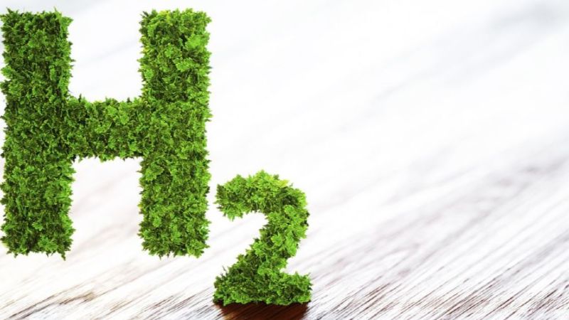 Grüner H2-Buchstabe vor Holzhintergrund. (Symbolbild)