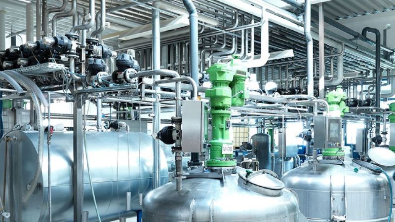 Einblick in die Produktion eines Reinigungsmittelproduzenten. Vor Maschinen steht ein Mitarbeiter.