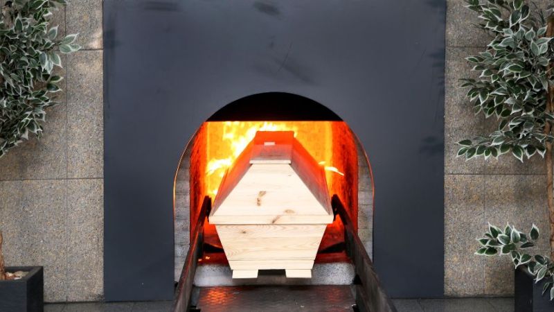 Sarg wird in einen Krematoriumsofen gefahren.