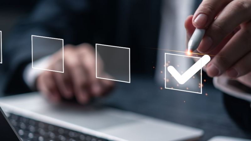 Personen arbeiten gemeinsam an einem Tisch mit Diagrammen, Notizbüchern und Laptops bei einem Meeting.