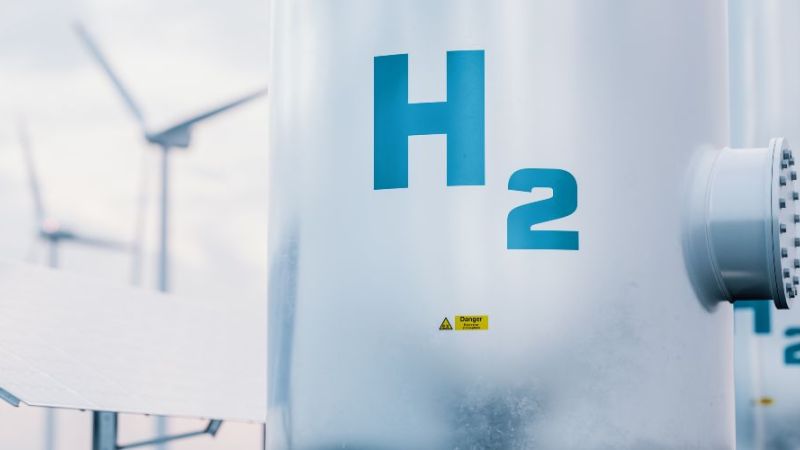 Ein Wasserstofftank und im Hintergrund Windräder und PV.