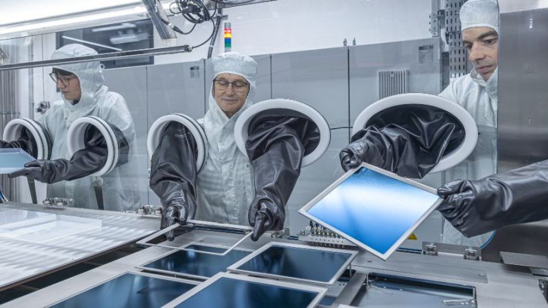 Wissenschaftlerinnen und Wissenschaftler an einer Verdampfer-Anlage mit großen Silizium-Wafern. Das Pero-Si-SCALE überführt die Zelldesigns aus dem Labor auf industrielle Zellformate.