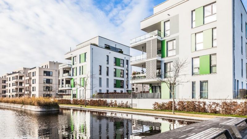 Wassernahes Neubauquartier mit begrünten Freiflächen – ein Beispiel für nachhaltige Quartiersentwicklung.