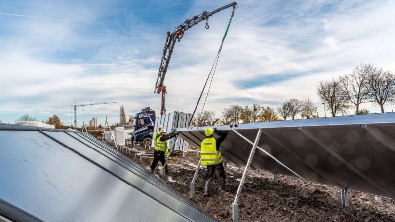 Arbeiter installieren solarthermische Anlagen.