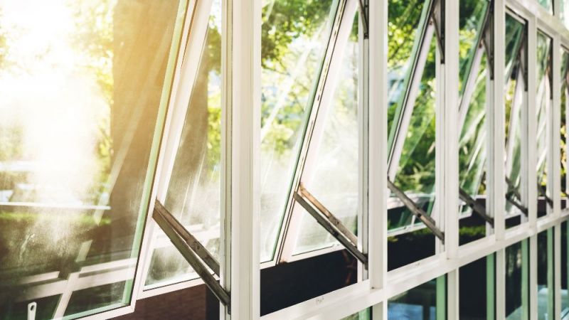 Eine Reihe geöffneter Fenster, durch die Lichts ins Gebäude fällt, ist zu sehen.