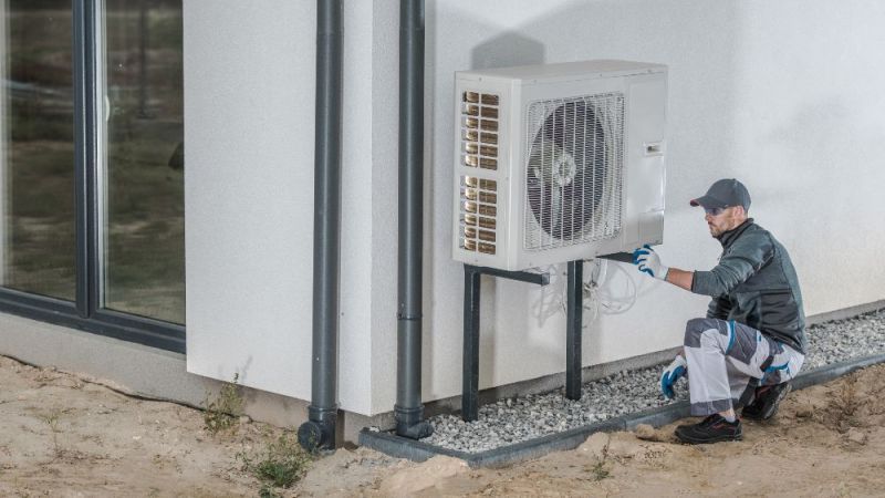 Handwerker installiert Wärmepumpe.