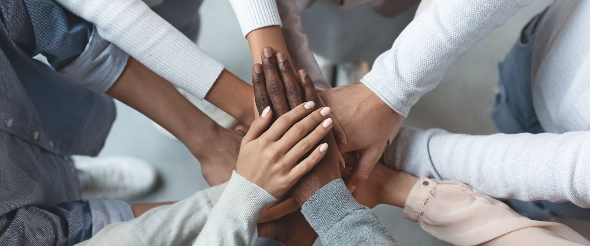 Uebereinander liegende Hände symbolisieren Zusammenarbeit