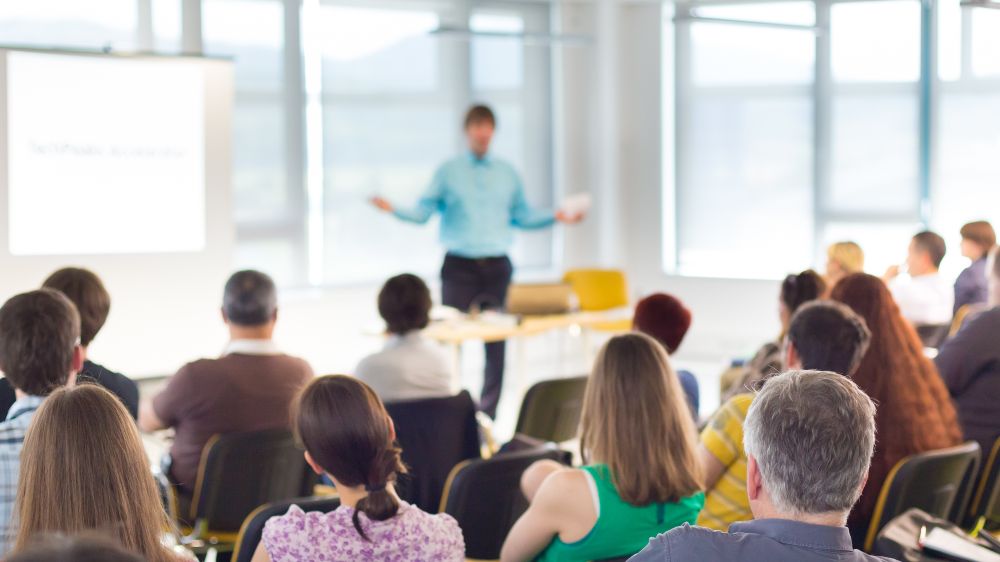 Person holding a speech in front of an audience