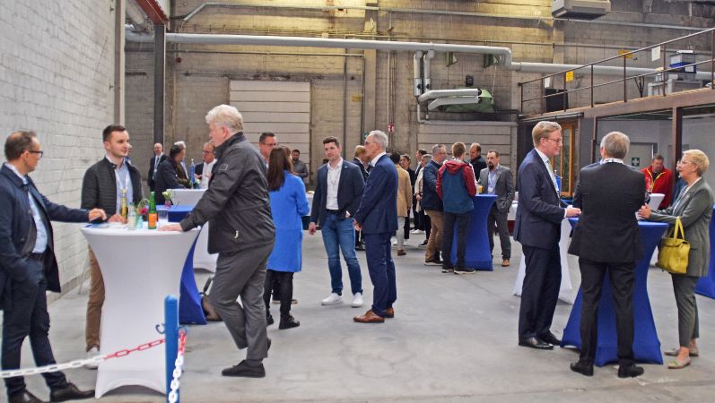 Beim Infotag bei REINTJES konnten sich Expertinnen und Experten zum Thema additive Fertigung in der mittelständischen Industrie austauschen. Besucher des Infotags bei REINTJES an Stehtischen diskutierend