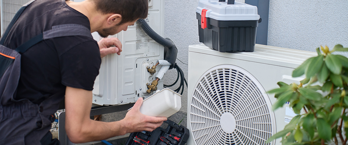 Handwerker wartet eine Wärmepumpe.