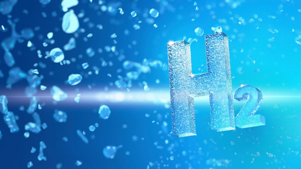 3D-Darstellung des chemischen Symbols H₂ für Wasserstoff, umgeben von schwebenden blauen Partikeln auf blauem Hintergrund. (Symbolbild)