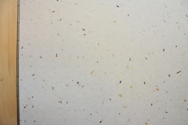 Eine Nahaufnahme zeigt eine weiße Küchenfront mit bunten Elementen. Sie wurde vollständig aus recyceltem Kunststoff aus Joghurtbechern hergestellt.