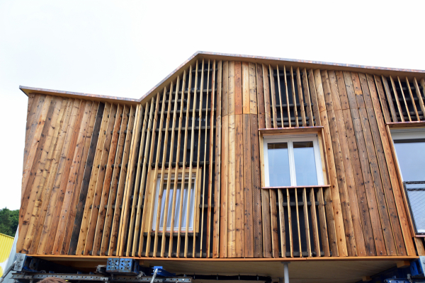 Die Holzfassade eines Gebäudes ist in einer Nahaufnahme zu sehen.