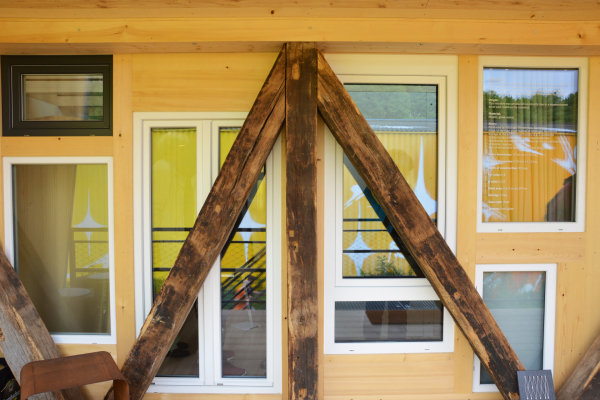 Auf der Nahaufnahme einer Fassade sind Fenster und Holzbalken zu sehen.