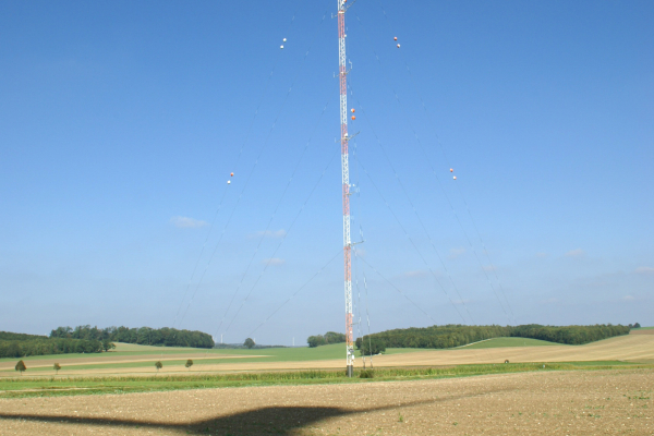 Schatten einer Forschungswindenergieanlage vor einem Windmessmast