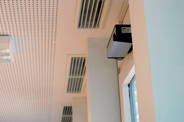 Forschungsfokus

Im Fokus des Teilprojektes stand die Untersuchung von passiven und aktiven Lüftungssystemen mit PCM zur Raumkühlung. Anhand von Messdaten wurden belastbare Systemkennwerte ermittelt und das energetische Potenzial solcher Systeme untersucht.

Im Rahmen des Projektes wurden neben einer hinterlüfteten Kühldecke mit PCM in einem Besprechungsraum auch PCM-Lüftungskompaktspeichergeräte und PCM-Brüstungsmodule in Büroräumen untersucht. Die hinterlüftete Kühldecke mit PCM wurde bereits im Rahmen eines Vorgängerprojektes installiert. Hierbei konnten Kühlleistungen von 15-30 W/m² bei Raumtemperaturen von 26-28°C ermittelt werden. Jetzt sollte die Regeneration des PCM mittels Nachtlüftung optimiert werden.

Deckenlufteinlässe und automatischer Aktor zur Öffnung der Fenster für den Regenerationsbetrieb